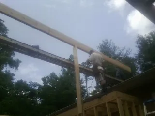 Carpenter setting a ridge beam over a new addition frame — Ice Dam Removal by Roofing Brothers in Lewiston Woodville