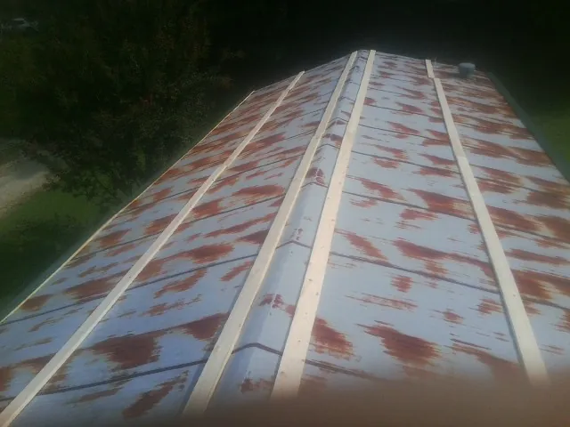 Rusted metal roof panels with new wood purlins before replacement — Storm Damage Roof Repair in Lewiston Woodville by Roofing Brothers