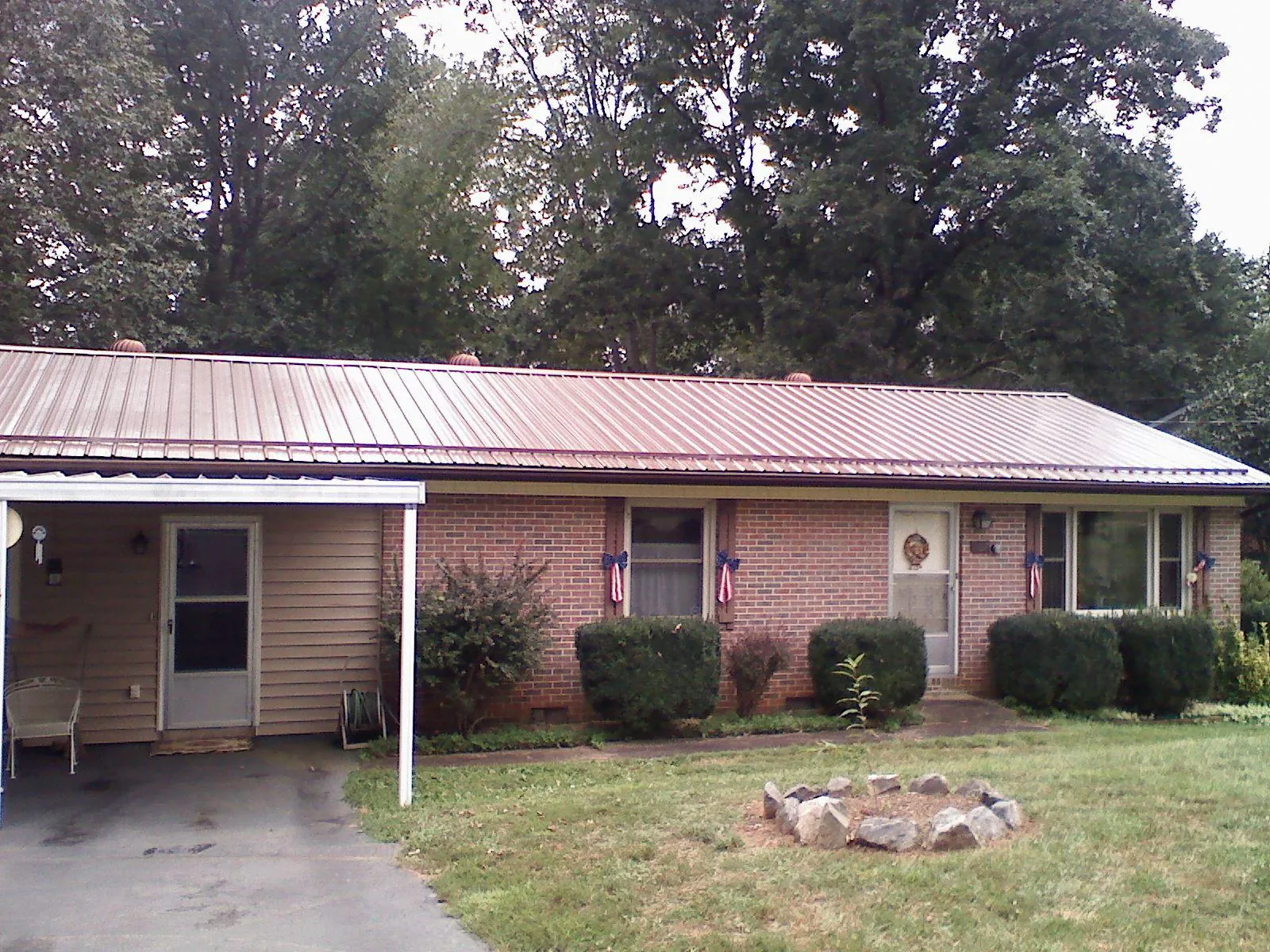 Bronze metal roof and carport on a brick ranch home — Roof Repair work by our crew in Lewiston Woodville